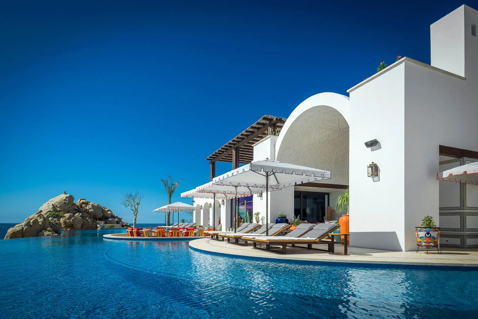Modern homes for sale in Pedregal oceanfront villa with floor-to-ceiling glass walls and infinity-edge pool overlooking the Pacific