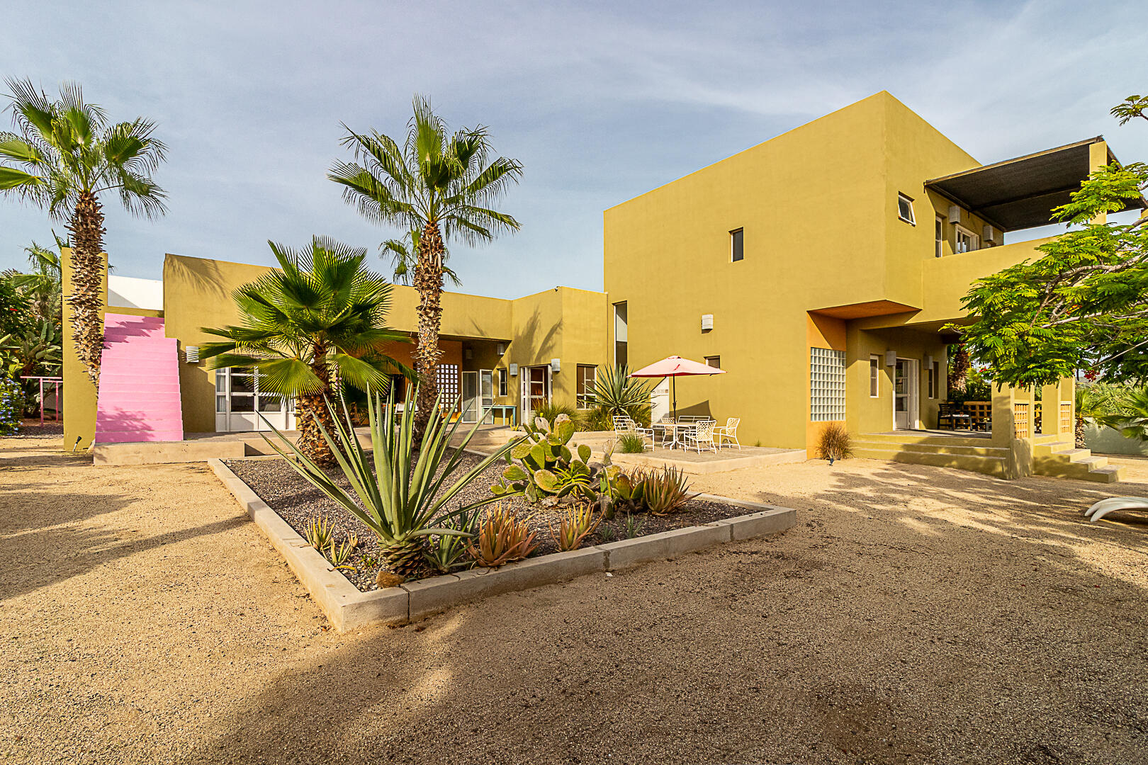 Pedregal Los Barriles This unique property is in a prime location.Just steps from the beautiful beaches of Los Barriles.You are in town so walking to multiple restaurants and shops is easy without a car.Upon entering from the street, on your left is the first garage with an attached bedroom,bathroom and a covered patio.The main house has 1 bedroom, 1 1⁄2 bathrooms, kitchen, dining area, laundry room and livingroom that opens to a large covered patio. On the other side of the patio are 2 bedrooms and 2bathrooms.Directly behind the 2 bedrooms and bathrooms is a casita with 1 bedroom, 1 bathroom, fullkitchen, dining area, living room, laundry room and covered patio.There is also a detached extra deep garage in the back of the property for storing cars, sideby sides, quads or gear. This 5-bedroom, 5.5-bathroom property with 2 garages and 2 laundry rooms is ideal for a winter getaway and offers great rental income opportunities. – Camino Colibri, Pacific, BS