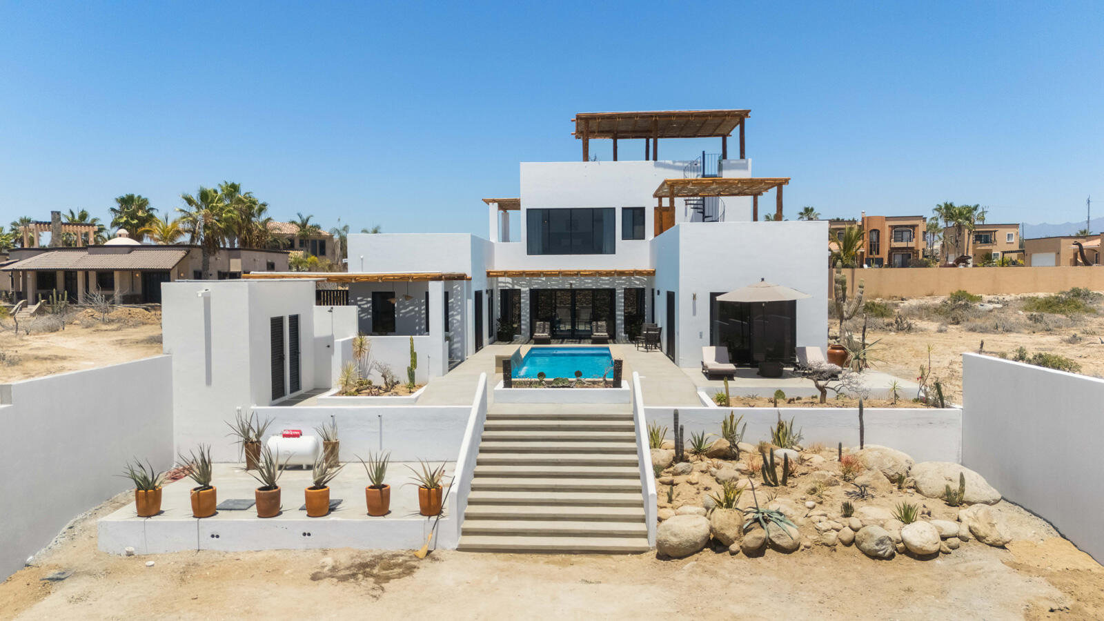 Pedregal El Posito We are excited to introduce Casa Elisabeth, an amazing, newly constructed custom home in the private El Posito area of Todos Santos. Located just three rows back from the beach, this three-bedroom, three-full and two-half bathroom residence offers every amenity desired for a tropical paradise. The downstairs features an open-concept living room, dining room, and a fully stocked kitchen with brand-new appliances, including a dishwasher. The main floor also includes a laundry room and an outdoor water feature with a professionally designed rock wall. The principal bedroom downstairs offers a unique indoor/outdoor bathroom with two showers and an outdoor bathtub.Each of the three bedrooms includes an en-suite bathroom with double vanities. The upstairs bedroom features its own private furnished terrace and access to one of four large patios, complete with a bar area and outdoor furniture perfect for enjoying ocean sunsets. Additionally, a shaded third-floor observation deck provides panoramic ocean and mountain – Casa Elisabeth, Pacific, Pacific, BS