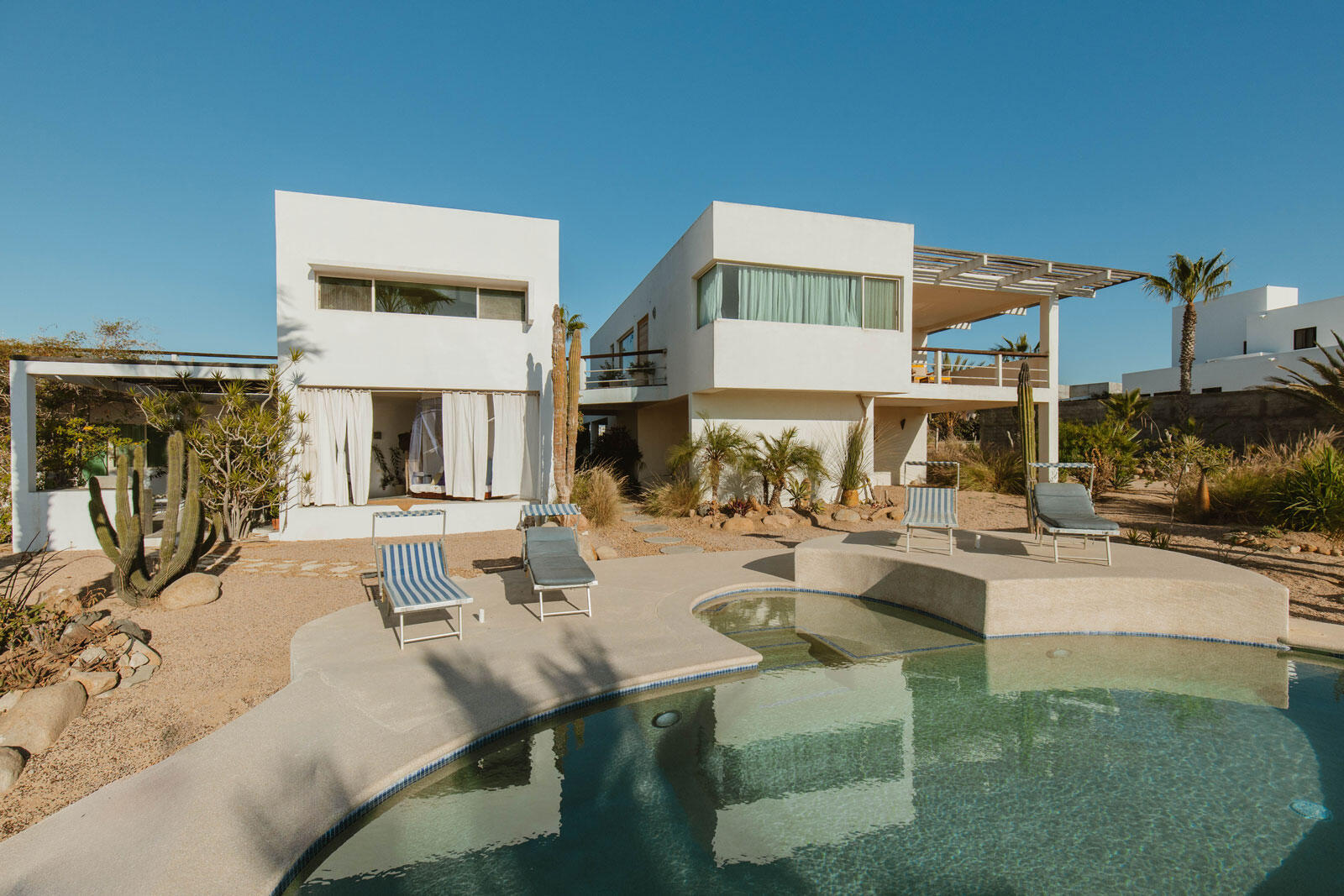 Pedregal Centro Casa Paloma, a delightful residence featuring 2 bedrooms, 2.5 bathrooms, a refreshing dipping pool, and ample space for parking a boat or RV.This newly constructed bungalow is just a few blocks from the beach and within a short walking, biking, or golf cart ride to the charming seaside Malecon and Loreto's historic town square, where you'll find a variety of restaurants and coffee shops.This inviting single-story home is situated on a secured lot and boasts an open-concept kitchen and living area. It includes a guest bedroom with a full bathroom, as well as a ensuite that opens up to the back patio, complete with a tranquil water feature, dipping pool, and outdoor shower. A convenient half bathroom is located by the poolside for easy access. Additionally this property also provides the potential for future expansion, whether you envision adding a second floor or expanding the ground level.This charming casita comes fully furnished and is perfect as a full-time residence, vacation retreat, or rental property. – Villa Pacifica, Pacific, BS